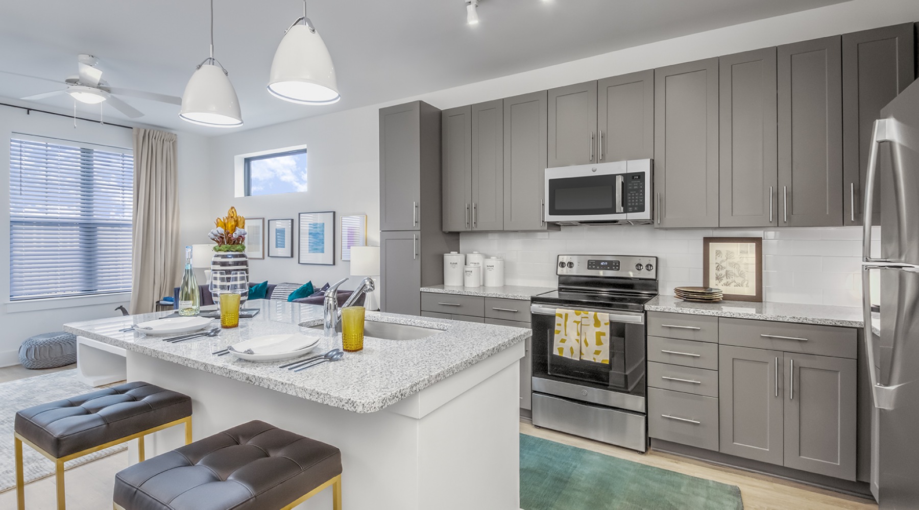 well lit kitchen with pendant lighting over island sink counter