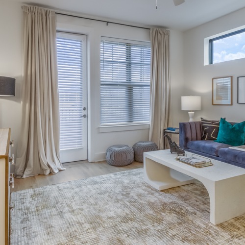 spacious living room with balcony and purple couch